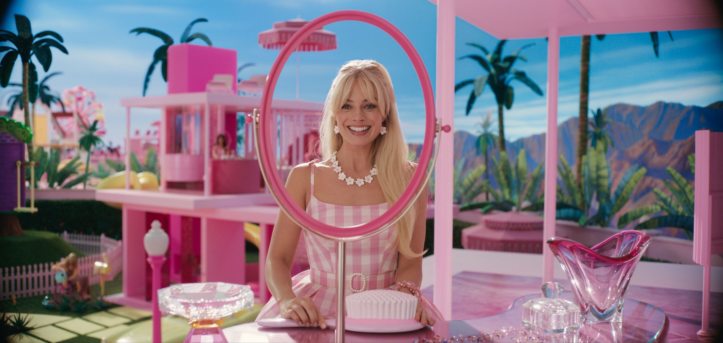 Margot Robbie smiles from a room inside her pink Dream House in the film Barbie.